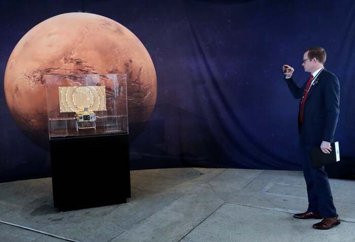(Marcio Jose Sanchez | The Associated Press) A man takes pictures of a model of the CubeSat MarCO which trails the InSight lander on its mission to Mars at NASA's Jet Propulsion Laboratory Monday, Nov. 26, 2018, in Pasadena, Calif. The technology onboard each CubeSat will provide NASA the ability to quickly transmit status information about InSight as it lands on Mars. A NASA spacecraft is just a few hours away from landing on Mars. The InSight lander is aiming for a Monday afternoon touchdown on what scientists and engineers hope will be a flat plain on the red planet.