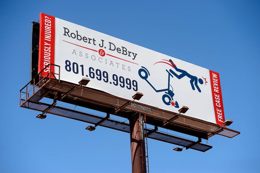 (Trent Nelson | The Salt Lake Tribune)  A billboard advertising legal services along I-15 in Salt Lake City shows a figure flying off a scooter, Monday Sept. 10, 2018.