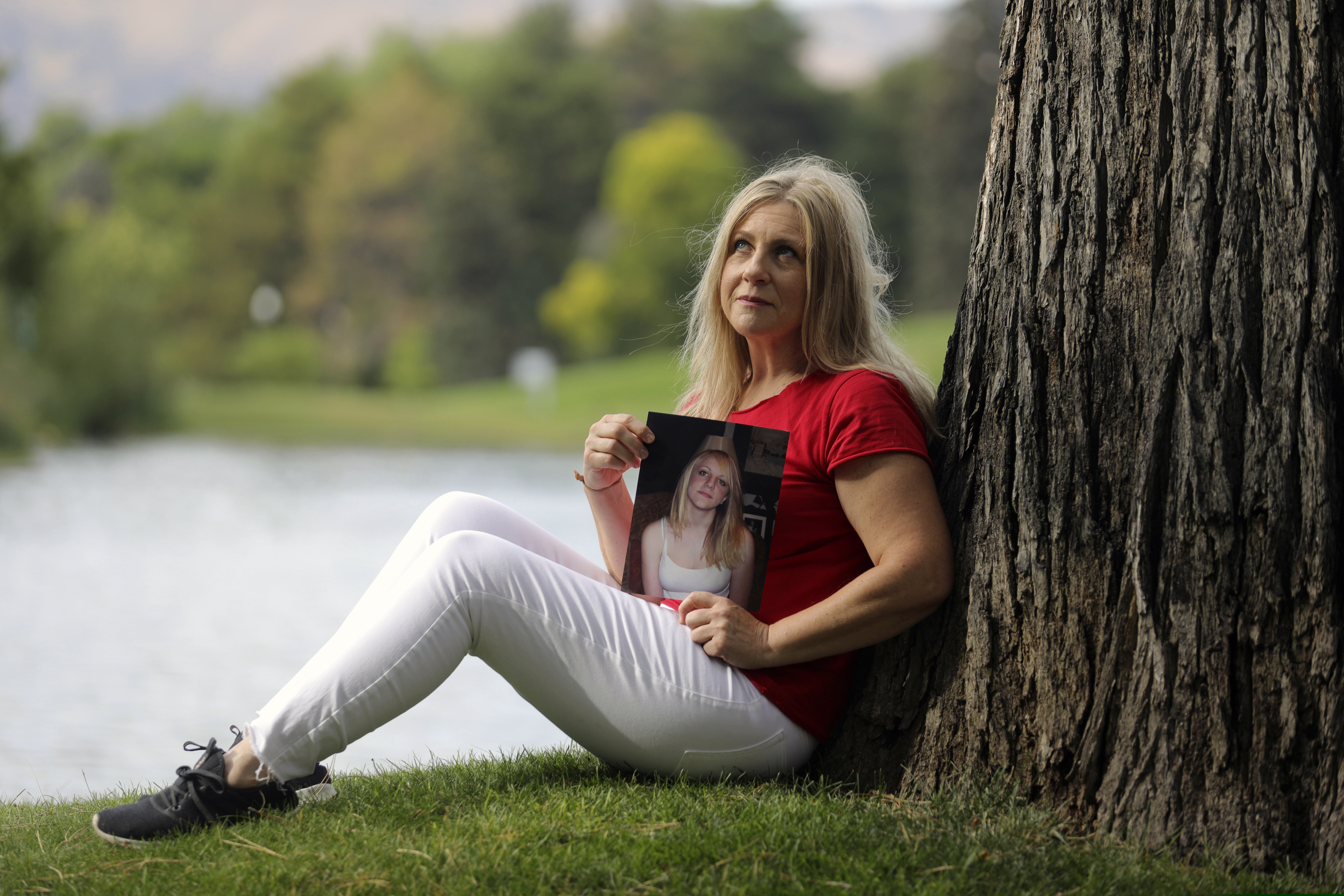 (Rick Bowmer | AP) Carolyn Tuft holds a portrait of her daughter Kirsten Hinckley in Salt Lake City on Thursday, Aug. 8, 2019. Tuft survived a 2007 mass shooting in Utah and said she has lead poisoning from shotgun pellets still in her body, leaving her with debilitating headaches, nausea and other serious health problems. Tuft, whose 15-year-old daughter died in the Trolley Square mall shooting in Salt Lake City, has been unable to work, resulting in the loss of her home and business, she told The Associated Press.