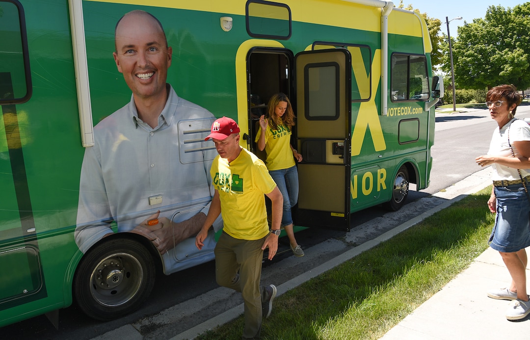(Francisco Kjolseth  |  The Salt Lake Tribune)  Lt. Gov. Spencer Cox makes a stop in Garland, Utah with his wife Abby, in background, as they meet with a constituent while touring the state in his dad's RV with a fresh wrap in John Deere colors. Along for part of the tour through Box Elder County were Senator Scott Sandall, (R-Tremonton) and his wife Christie, at right.