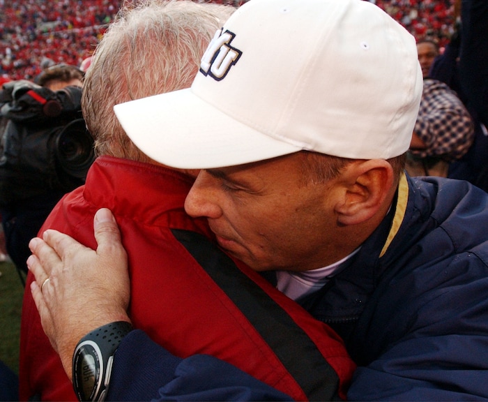 (Tribune File Photo)  Utah coach Ron McBride (left) and BYU coach Gary Crowton exchange a hug at the end of the rivalry game on November 23, 2002. Utah beat BYU 13-6.