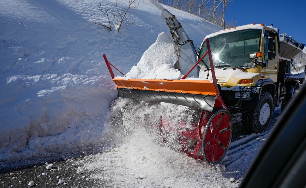 (Francisco Kjolseth | The Salt Lake Tribune) Crews work to cut away walls of snow to widen the road above Park City during a record snowfall year on Thursday, March 16, 2023. 
