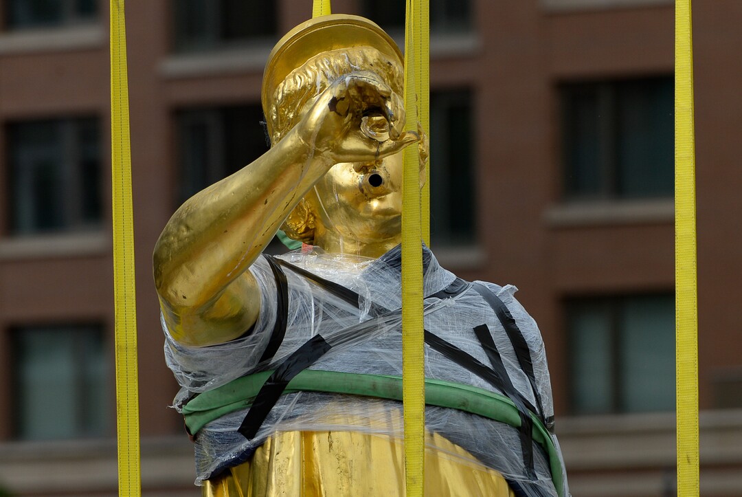 (Francisco Kjolseth  |  The Salt Lake Tribune) People gather to get a closer look of the Angel Moroni statue after it was pulled from atop the Salt Lake Temple of The Church of Jesus Christ of Latter-day Saints on Monday, May 18, 2020. The temple closed in December for seismic upgrades and sustained minor damager during the March 18, 2020, magnitude 5.7 earthquake when the trumpet held by the angel fell off and several smaller spire stones were displaced.