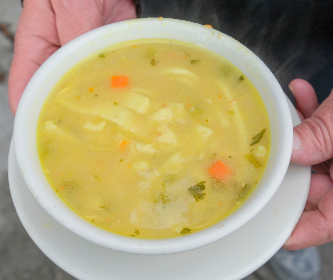 (Leah Hogsten  |  The Salt Lake Tribune) Drake Aitken serves up The Soup Kitchen's most popular chicken noodle soup, Dec. 18, 2020.
