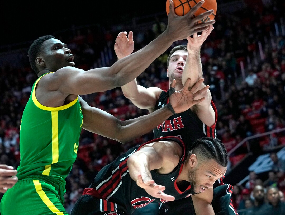 (Leah Hogsten | The Salt Lake Tribune) Utah Utes guard Marco Anthony (10) stays low as Utah Utes guard Rollie Worster (25) battles Oregon Ducks center N'Faly Dante (1) for the rebound as the University of Utah hosts Oregon at the Huntsman Center, Jan. 7, 2023.