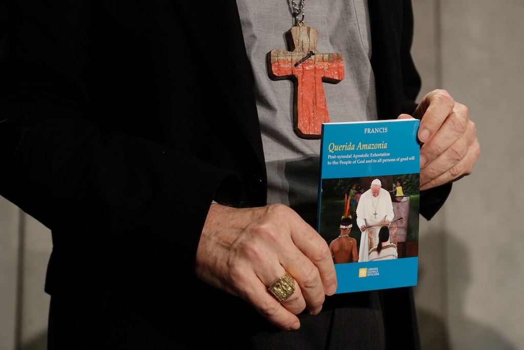 (AP Photo/Gregorio Borgia) Cardinal Michael Czerny holds a copy of the post-synodal apostolic exhortation "Querida Amazonia" written by Pope Francis during a news conference at the Vatican, Wednesday, Feb. 12, 2020.