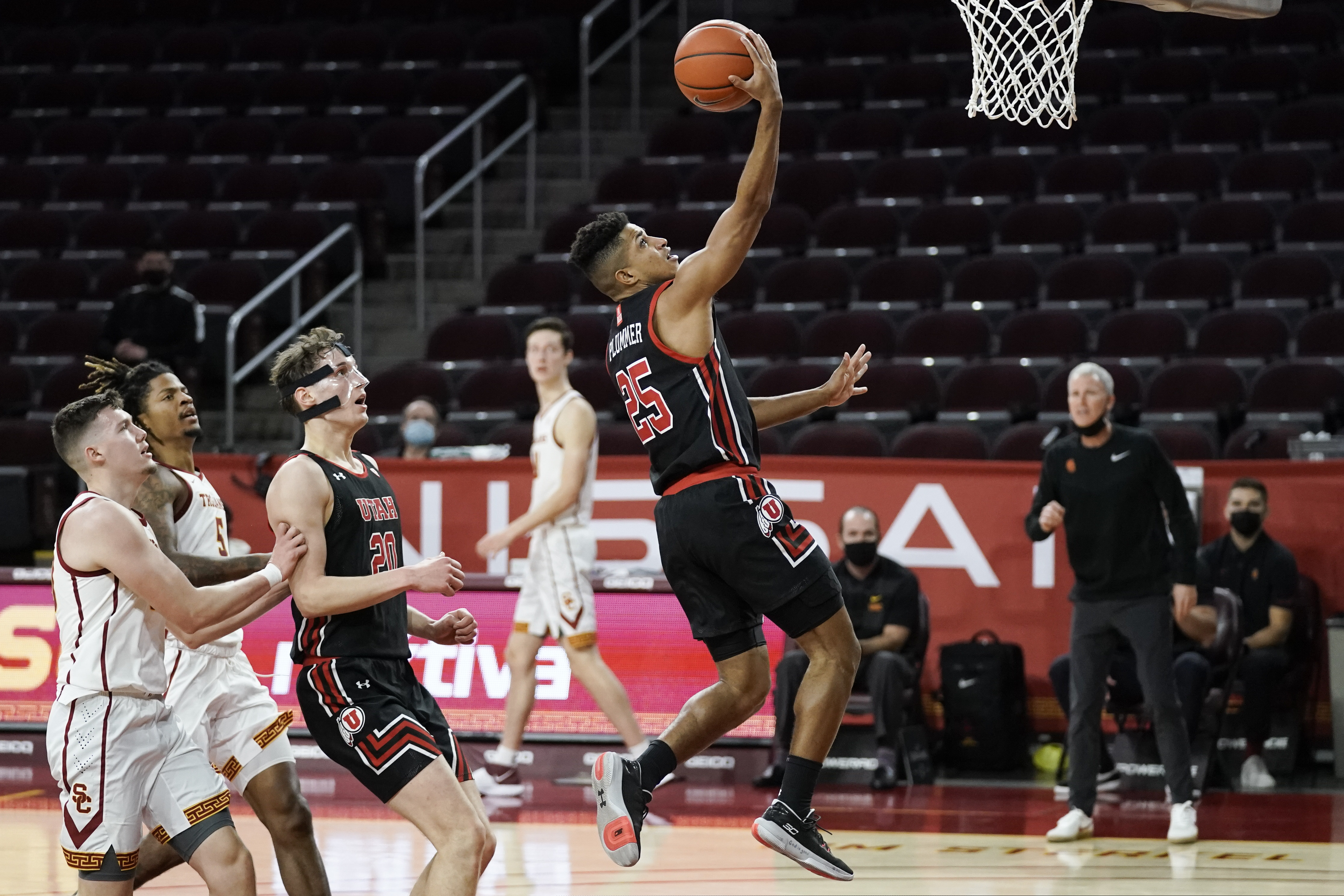 Utah's Alfonso Plummer, center, drives to the basket during the first half of an NCAA college basketball game against Southern California, Saturday, Jan. 2, 2021, in Los Angeles. (AP Photo/Jae C. Hong)