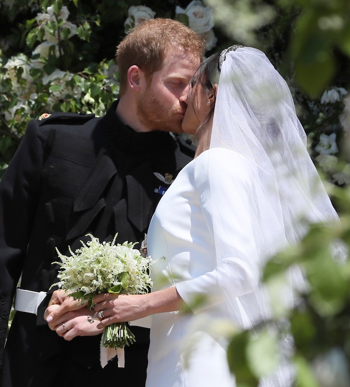 Meghan Markle and Prince Harry kiss on the steps of St George's Chapel at Windsor Castle following their wedding in Windsor Castle in Windsor, near London, England, Saturday, May 19, 2018.(Brian Lawless/pool photo via AP)