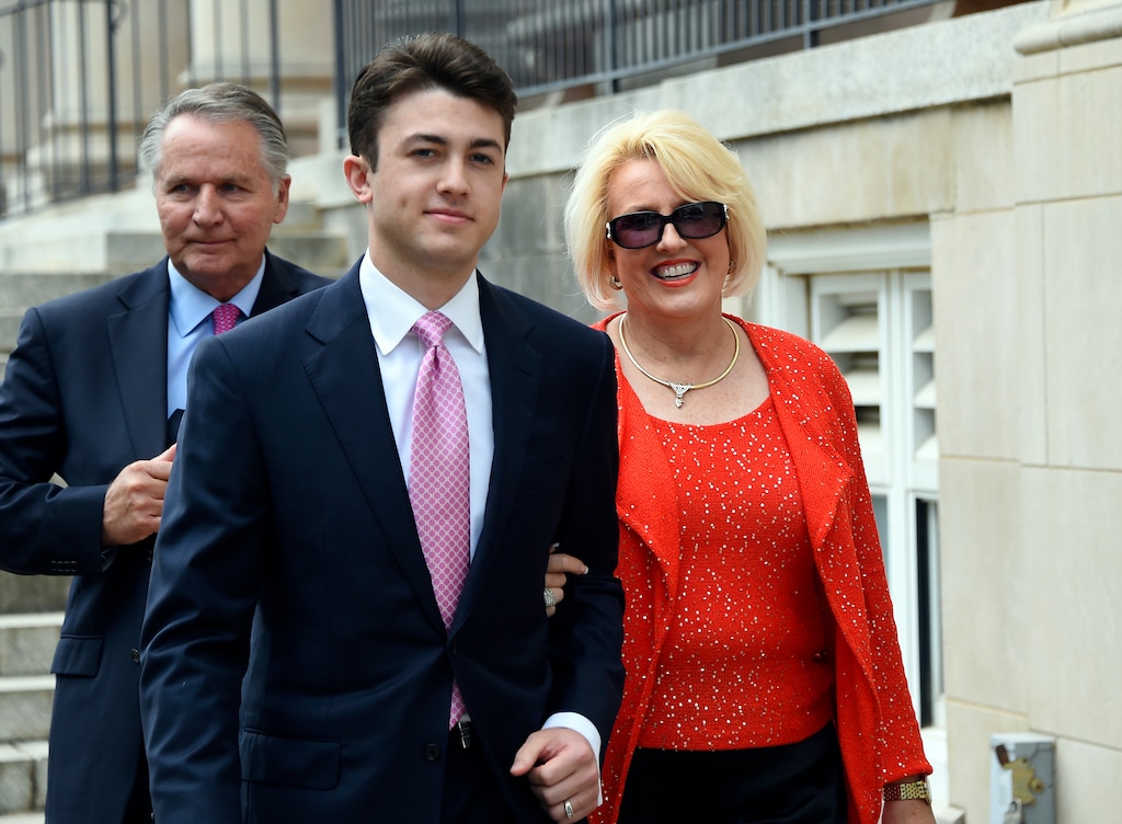 FILE - In this May 19, 2017, file photo, Brooke Covington, right, a member of the Word of Faith Fellowship church in Spindle, N.C., leaves a hearing at Rutherford County Courthouse, background, in Rutherfordton, N.C., accompanied by an attorney, Joshua Valentine, left, and her husband, Kent Covington. A man has been charged with harassing the jury that is deliberating in the trial of Brooke Covington, a North Carolina minister accused of beating a congregant to expel his “homosexual demons.” The man apparently made a comment Tuesday, June 6, 2017, to the jurors in a hallway that they needed to reach a verdict. Deliberations began Monday, June 5. (AP Photo/Kathy Kmonicek, File)