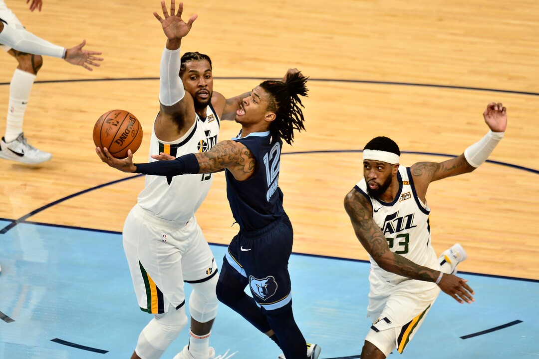Memphis Grizzlies guard Ja Morant (12) shoots between Utah Jazz forward Royce O'Neale (23) and center Derrick Favors in the first half of Game 4 of an NBA basketball first-round playoff series Monday, May 31, 2021, in Memphis, Tenn. (AP Photo/Brandon Dill)
