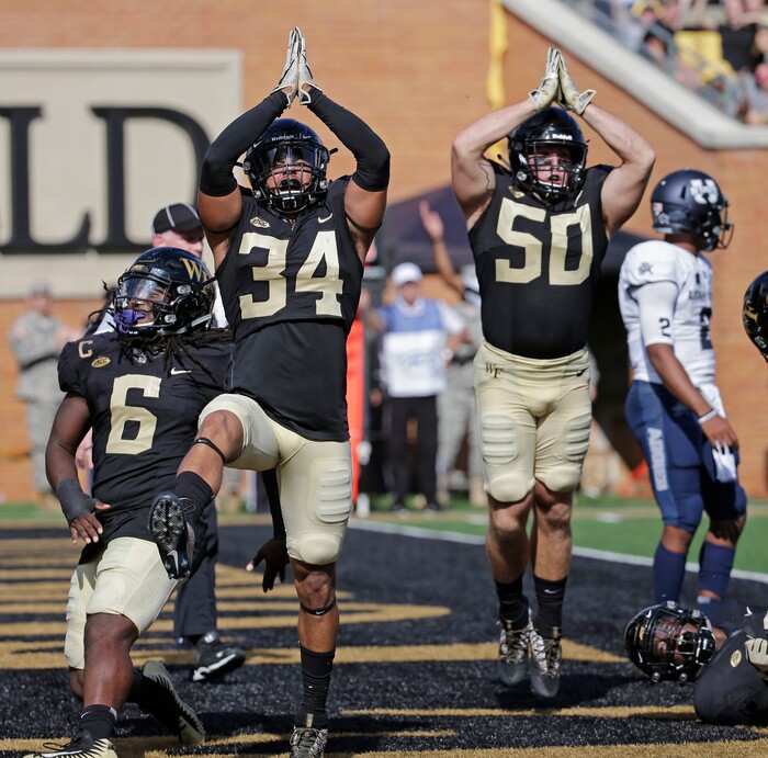 Wake Forest's Demetrius Kemp (34), Grant Dawson (50) and Jaboree Williams (6) celebrate a safety against Utah State in the first half of an NCAA college football game in Winston-Salem, N.C., Saturday, Sept. 16, 2017. (AP Photo/Chuck Burton)