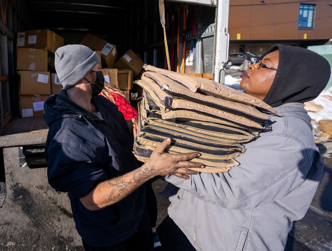 (Rick Egan | The Salt Lake Tribune) Georgia and loads up blankets donated by the Sikh community, into the arms of Ty Bellamy with Black Lives for Humanity, to distribute to people in camps in Salt Lake, to help the unsheltered stay warm,  Thursday, December 23, 2021.