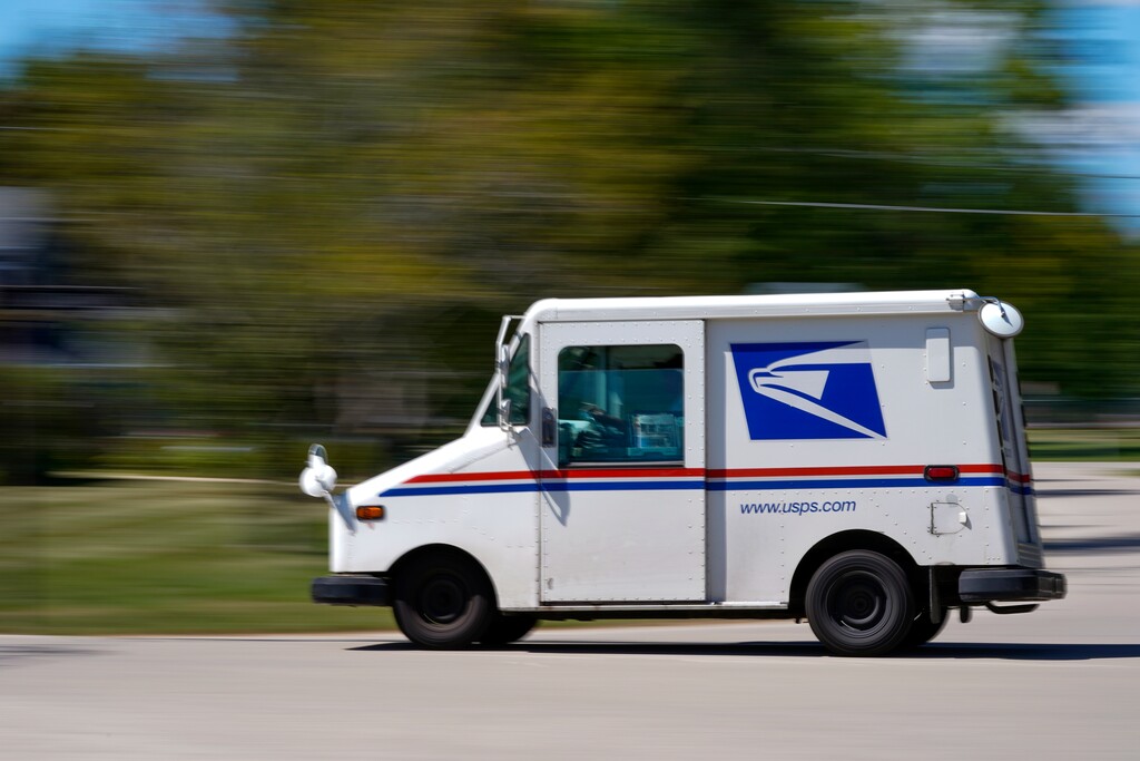 (Morry Gash | AP) A mail truck moves down a street Tuesday, Aug. 18, 2020, in Fox Point, Wis. Facing public pressure and state lawsuits, the Postmaster general announced Tuesday he is halting some operational changes to mail delivery that critics warned were causing widespread delays and could disrupt voting in the November election.