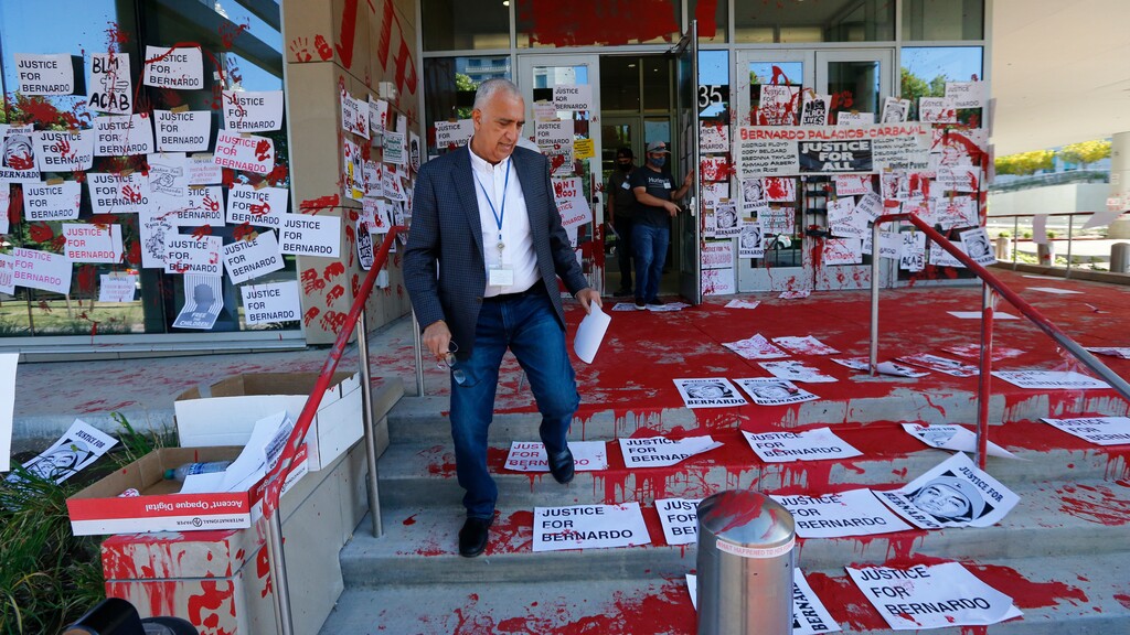 District Attorney Sim Gill inspects the damage to the district attorney's office Friday, July 10, 2020, in Salt Lake City. Protesters decrying the police shooting of Bernardo Palacios-Carbajal painted and marked the district attorney's office Thursday, July 9, 2020, night, after two police officers in Utah were cleared in his death. (AP Photo/Rick Bowmer)