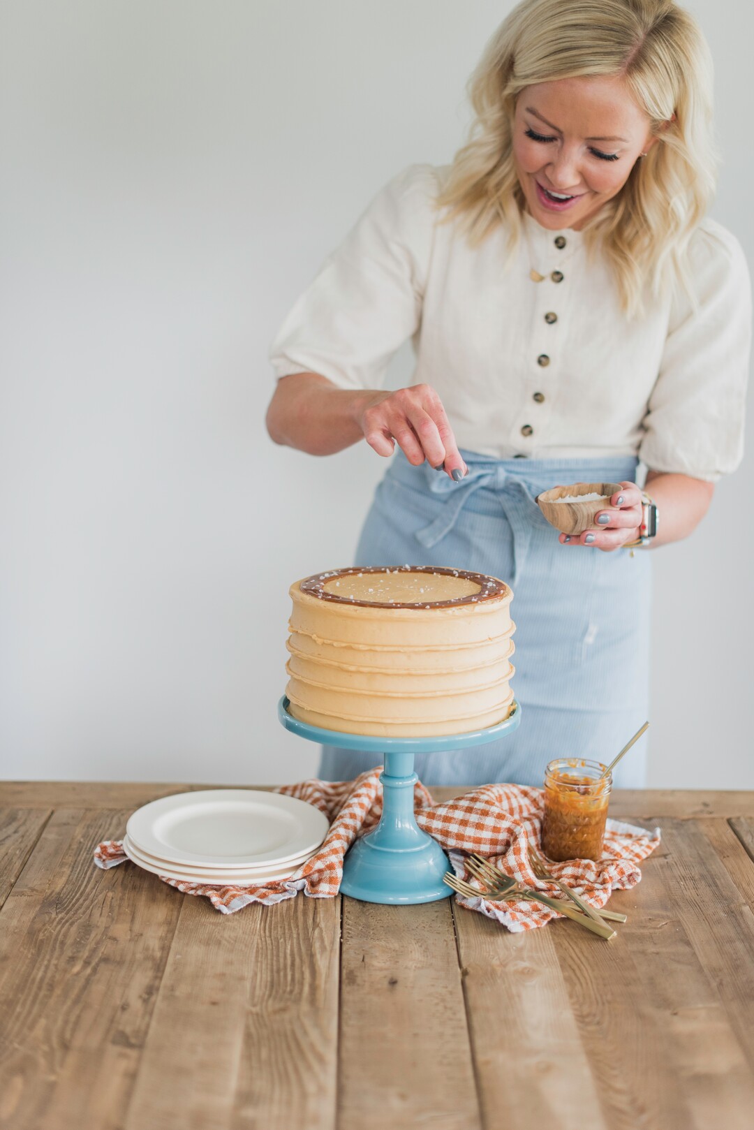 (Photo by Trina Harris Photography | Courtesy of Courtney Rich) Courtney Rich adds flakes of salt to her Caramel Cake.
