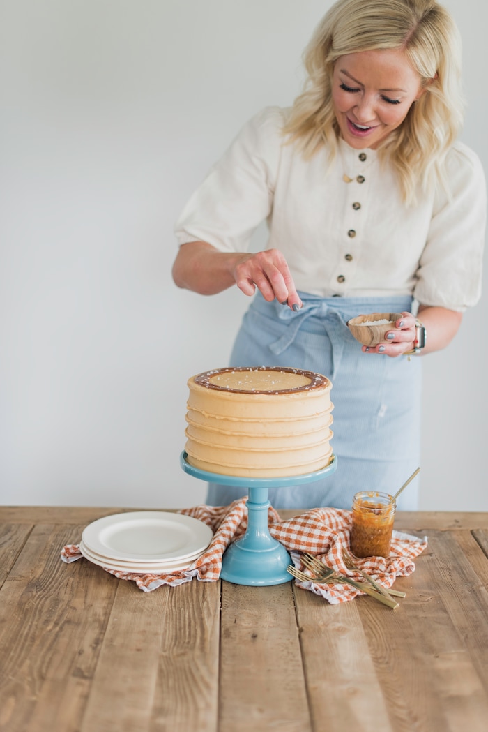 (Photo by Trina Harris Photography | Courtesy of Courtney Rich) Courtney Rich adds flakes of salt to her Caramel Cake.