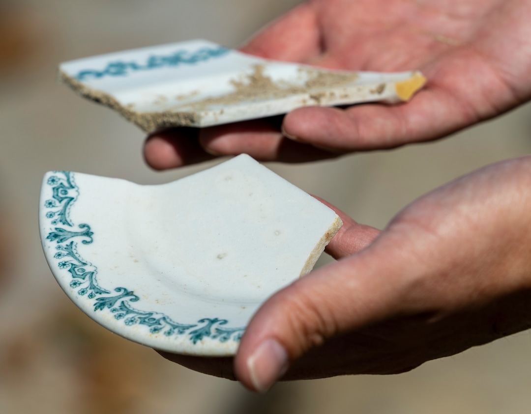 (Leah Hogsten | The Salt Lake Tribune) Christopher Merritt, a state historic preservation officer, holds plate shards Thursday, July 21, 2022, that can be seen sticking out of the sand at the former location of the Saltair Resorts on the Great Salt Lake. The plates  would've been used at Saltair in the 1920s and 30s.