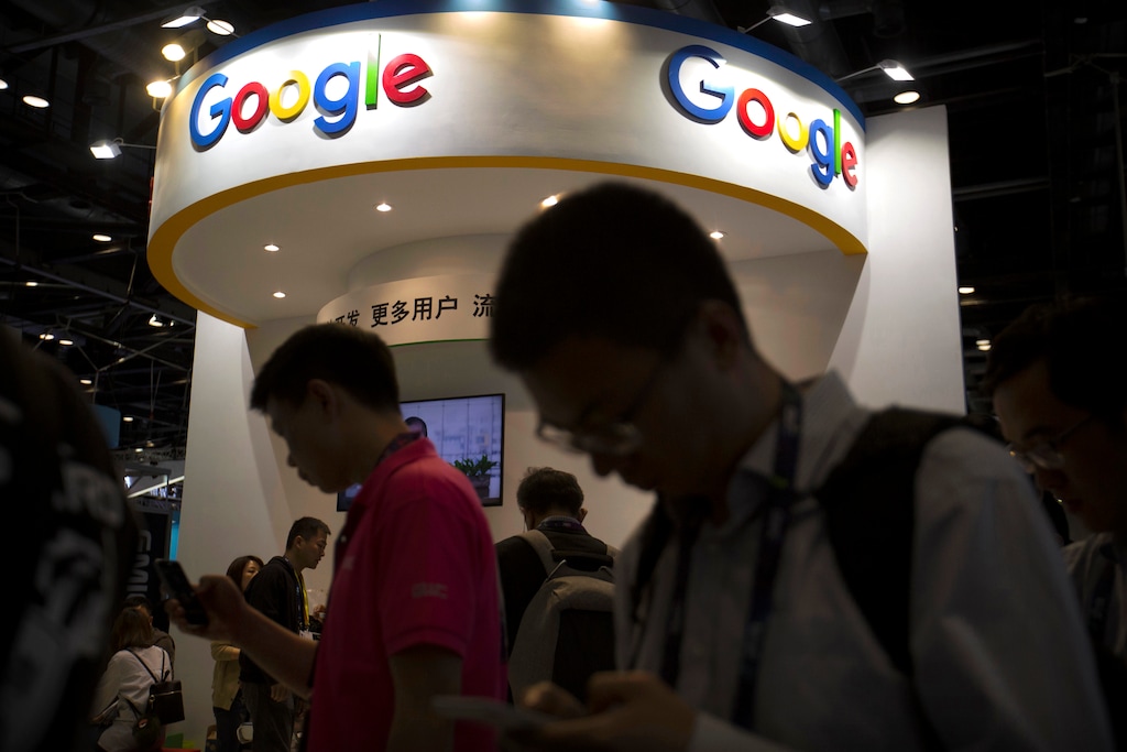 (AP Photo/Mark Schiefelbein, File) In this April 27, 2017, file photo, visitors use their smartphones in front of a booth for Google at the Global Mobile Internet Conference (GMIC) in Beijing. More than a dozen human rights groups have sent a letter dated Tuesday, Aug. 28, 2018, to Google urging the company not to offer censored internet search in China, amid reports it is planning to again begin offering the service in the giant Asian market.