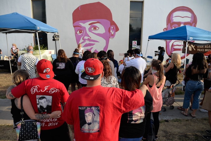 (Francisco Kjolseth  |  The Salt Lake Tribune) People gather for a vigil on the six-year anniversary of Dillon Taylor’s death by the murals of people killed by police near 800 South and 300 West in Salt Lake City on Tuesday, August 11, 2020. Multiple families who’s loved one’s are depicted on the walls joined the vigil as they moved from portrait to portrait to remember them.