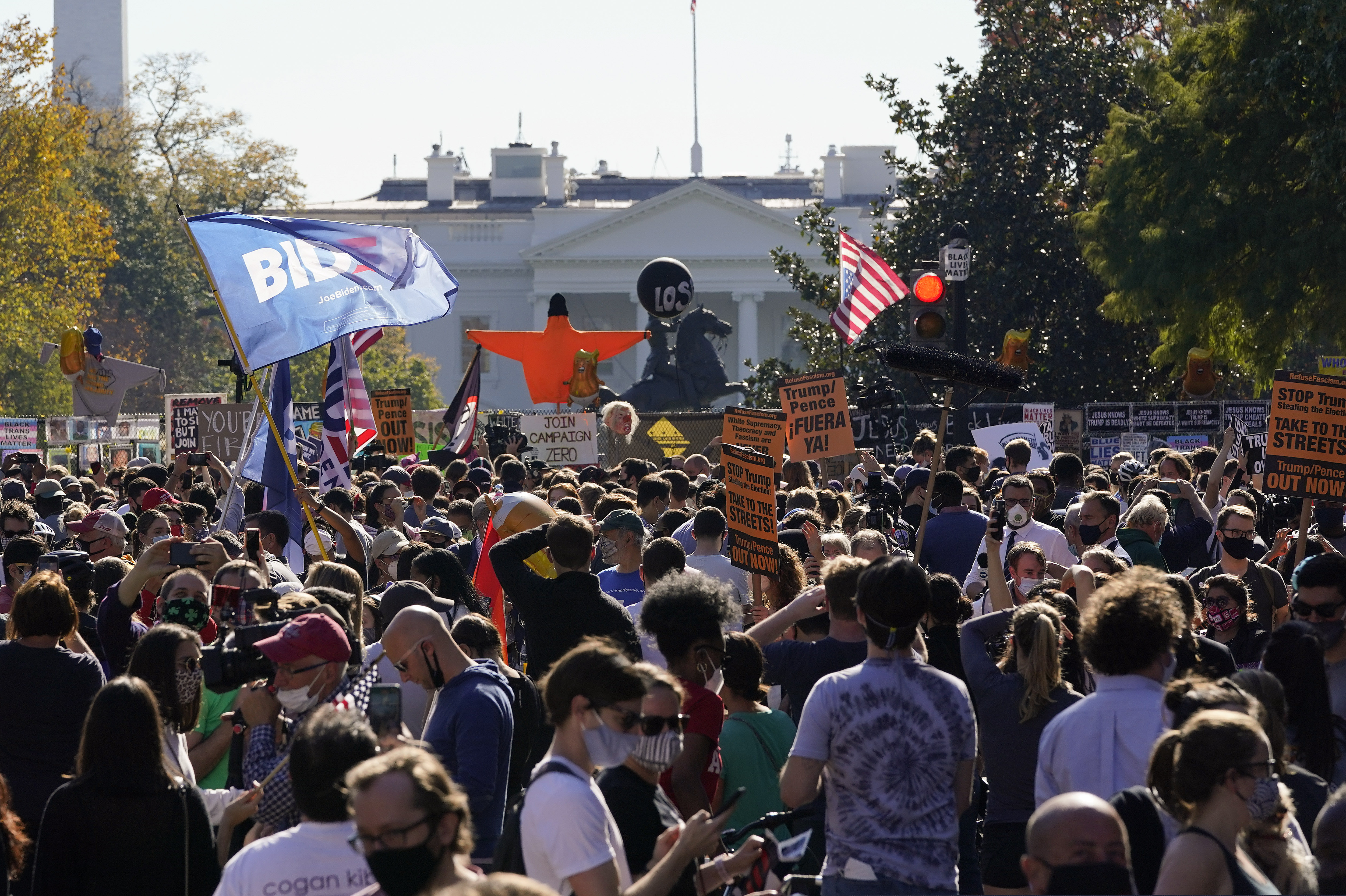 People gathered in Black Lives Matter Plaza react to the presidential race being called by CNN in Democratic presidential candidate Joe Biden's favor over Pres. Donald Trump to become the 46th president of the United States, Saturday, Nov. 7, 2020, in Washington. His victory came after more than three days of uncertainty as election officials sorted through a surge of mail-in votes that delayed the processing of some ballots. (AP Photo/Alex Brandon)