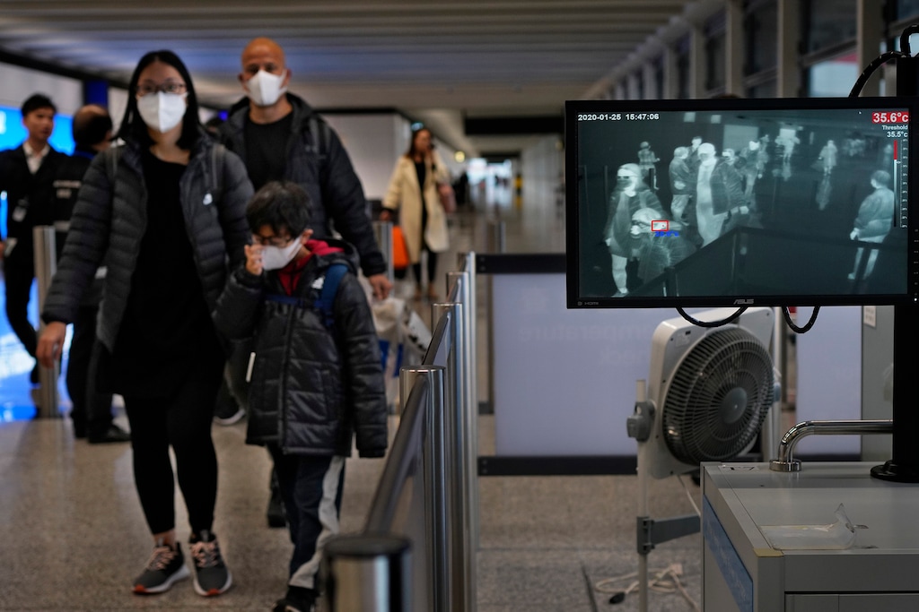(Vincent Yu | AP) Health surveillance officer use temperature scanner to monitor passengers arriving at Hong Kong International Airport in Hong Kong Saturday, Jan. 25, 2020. Hong Kong has declared the outbreak of a new virus an emergency and will close primary and secondary schools for two more weeks after the Lunar New Year holiday. City leader Carrie Lam also announced Saturday that trains and flights from the city of Wuhan would be blocked.