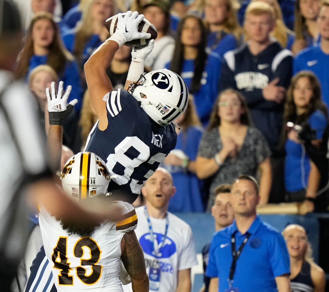 (Francisco Kjolseth | The Salt Lake Tribune) Brigham Young Cougars tight end Isaac Rex (83) pulls in the Cougars first touchdown as Wyoming Cowboys linebacker Shae Suiaunoa (43) pressures in football action between the Brigham Young Cougars and the Wyoming Cowboys at LaVell Edwards Stadium in Provo, on Saturday, Sept. 24, 2022.