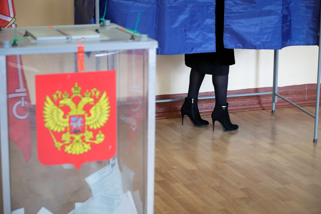 A woman stands in a polling booth at a polling station during presidential elections in St.Petersburg, Russia, Sunday, March 18, 2018. Russians are voting in a presidential election in which Vladimir Putin is seeking a fourth term in the Kremlin. (AP Photo/Dmitri Lovetsky)