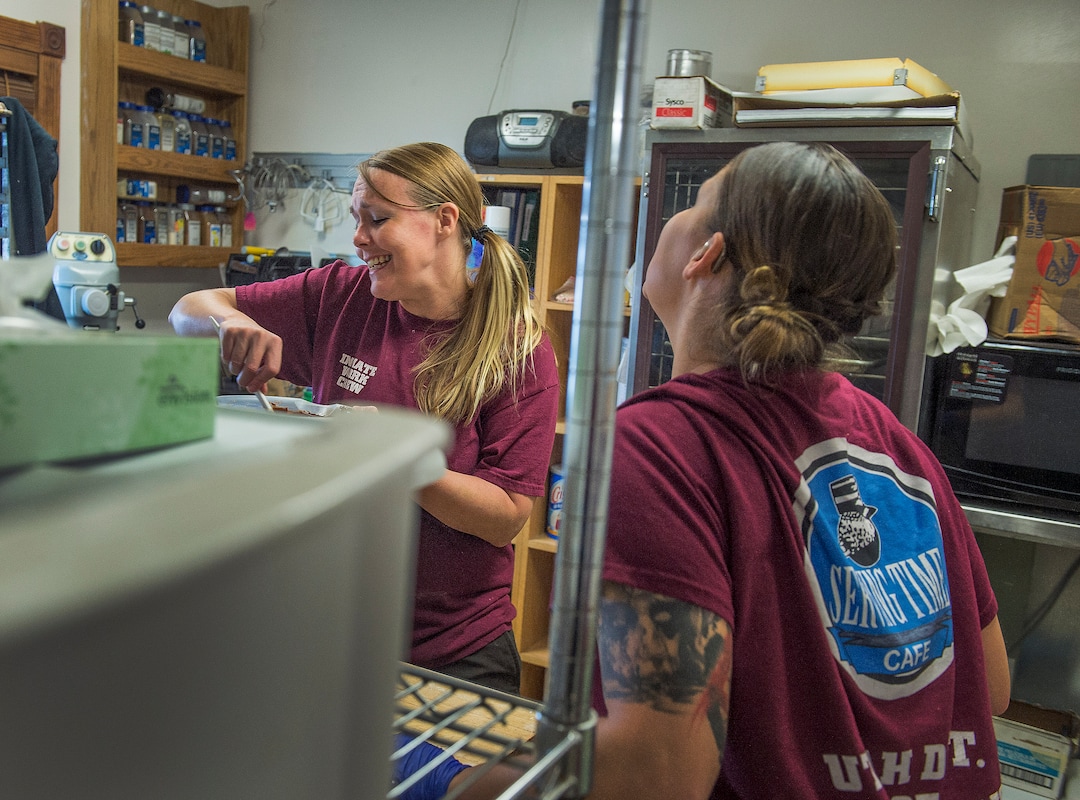 (Leah Hogsten  |  The Salt Lake Tribune) Chonsey Leslie, right, steps into the baking room to belt out a tune with Brittney Christensen, left, as country music blares on the radio as Christensen makes a pan of brownies and Leslie minds the deep fryer. Every Monday through Friday, a half-dozen or so Level 4 inmates file out of the Olympus Facility at the Utah State Prison to cook, bake and serve the public at the Serving Time Caf. The operation is part of Utah Department of Corrections Industries (UCI) and is aimed at helping inmates return to society.