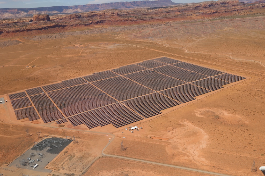 This Aug. 24, 2017, photo provided by Navajo Nation Office of the President and Vice President shows solar panels near famed sandstone buttes along the Arizona-Utah border on the Navajo Nation. The Kayenta Solar Facility is the first utility-scale solar project on the reservation, producing enough electricity to power about 13,000 Navajo homes. (Antonio Ramirez/Navajo Nation Office of the President and Vice President via AP)