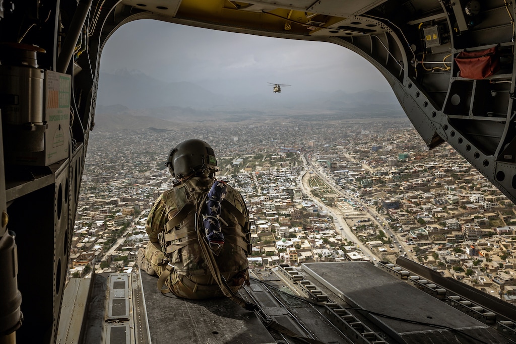 (Jim Huylebroek | The New York Times)
An American soldier on a CH-47 Chinook helicopter flying over Kabul, Afghanistan's capital, on May 2, 2021. "On the left, many now reject the idea that America can be or is a global champion of democracy," writes New York Times columnist David Brooks. "On the right the wall-building caucus has given up on the idea that the rest of the world is even worth engaging."