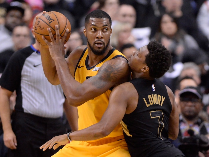 Utah Jazz forward Derrick Favors looks to pass as Toronto Raptors guard Kyle Lowry (7) defends during the second half of an NBA basketball game Friday, Jan. 26, 2018, in Toronto. (Frank Gunn/The Canadian Press via AP)