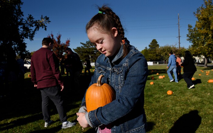 (Francisco Kjolseth  |  The Salt Lake Tribune)  Monet Heath, 15, embraces her pumpkin as students at Jordan Valley School in Midvale, Canyon District's school for students with severe disabilities, get a chance to pick out a pumpkin from their very own patch set up in front of the school on Wed. Oct. 24, 2018. Inmates who take part in the Green Thumb Nursery program at the Utah State prison grew and harvested the pumpkins that were donated to the school for the 10th year.