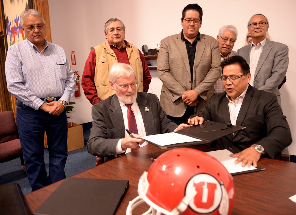 Al Hartmann  |  The Salt Lake TribuneDavid W. Pershing, University of Utah president, front left, and Gordon Howell, chairman of the Ute Indian Tribe Business Committee sign a memorandum of understanding outlining the University’s continued use of the Ute name for its athletics teams.  Members of the Ute Business Committe in rear watch the signing at a ceremony at Fort Duchesne Tuesday April 15. 