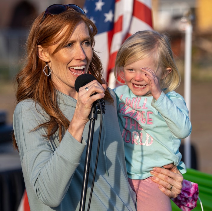 (Rick Egan | The Salt Lake Tribune)  Jennie Taylor holds her daughter Caroline, as she says a few words, during the Earth Day Party at the Mini Taylor farm at at the Jennie Taylor's residence, in North Ogden. Taylor is the widow to the late Major. Brent Taylor, killed in 2018 while on Army National Guard duty in Afghanistan, donations have helped restore the small family farm, with planter boxes, a chicken coop, and a sandbox for the kids, on Thursday, April 22, 2021.