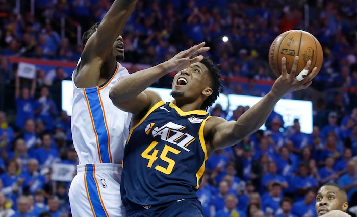 Utah Jazz guard Donovan Mitchell (45) shoots as Oklahoma City Thunder forward Jerami Grant, left, defends in the second half of Game 1 of an NBA basketball first-round playoff series in Oklahoma City, Sunday, April 15, 2018. (AP Photo/Sue Ogrocki)