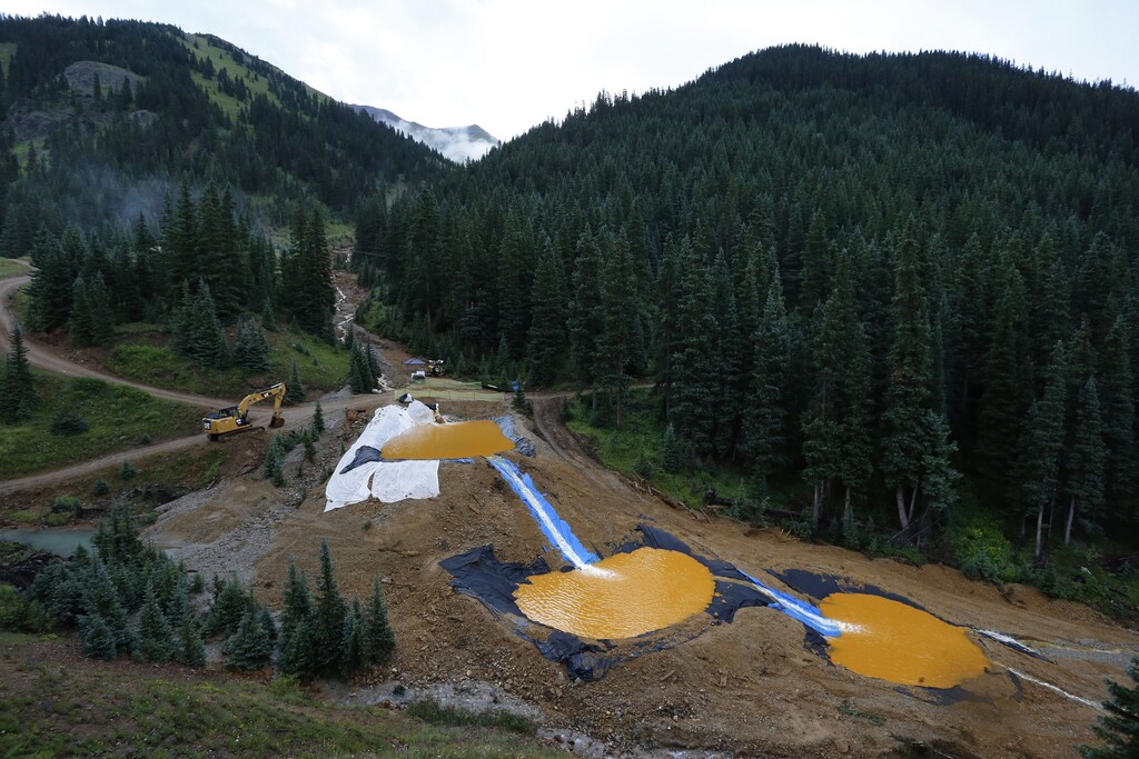 FILE - In this Aug. 12, 2015 file photo, water flows through a series of retention ponds built to contain and filter out heavy metals and chemicals from the Gold King mine chemical accident, in the spillway about 1/4 mile downstream from the mine, outside Silverton, Colo. A U.S. House probe of the mine waste accident in Colorado that fouled rivers in three states with arsenic, lead and other toxic substances has found further evidence that EPA workers knew a spill from the gold mine was possible, according to documents released Thursday, Feb. 11, 2016 by a U.S. House committee.  (AP Photo/Brennan Linsley, file)