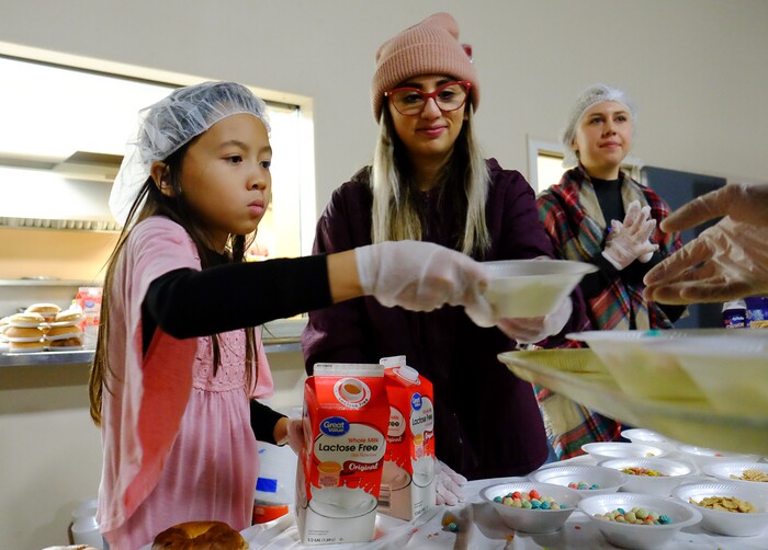 (Francisco Kjolseth | The Salt Lake Tribune) Grace Valle, 9, Fernanda Rubilar and Josie Wahl, from left, hand out breakfast while other volunteers ready the Thanksgiving banquet at the Salt Lake City Mission at 1055 North Redwood Road in Salt Lake City, on Thursday, Nov. 28, 2019.