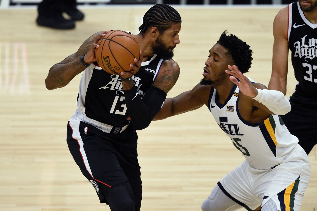 (Kelvin Kuo | AP) Los Angeles Clippers guard Paul George, left, holds on to the ball while Utah Jazz guard Donovan Mitchell defends during the first half of an NBA basketball game in Los Angeles, Friday, Feb. 19, 2021.