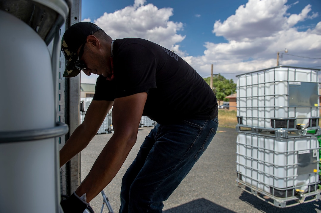(Leah Hogsten  |  The Salt Lake Tribune) Donovan Smallcanyon, a solar and water technician on the Navajo Water Project for DigDeep, manuvers a 250-gallon water tank in Dilkon, Ariz., June 23, 2020. Smallcanyon keeps solar-powered panel systems and propane hot water heaters working and fills cisterns at least once a month for residents in Navajo Mountain and Piute Mesa in San Juan County.