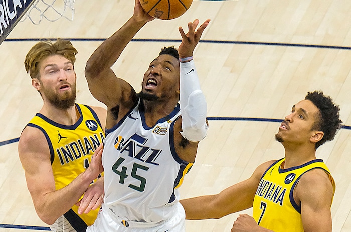 (Leah Hogsten | The Salt Lake Tribune) Utah Jazz guard Donovan Mitchell (45) hits the net past Indiana Pacers forward Domantas Sabonis (11) and Indiana Pacers guard Malcolm Brogdon (7) as the Utah Jazz host the Indiana Pacers, April 16, 2021 at the Vivint Arena.