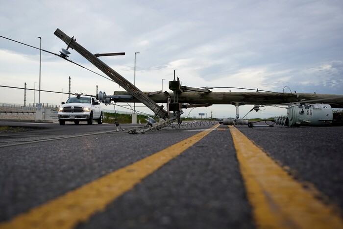 Down power lines stretch across a road in the aftermath of Hurricane Laura Thursday, Aug. 27, 2020, in Sabine Pass, Texas. (AP Photo/Eric Gay)