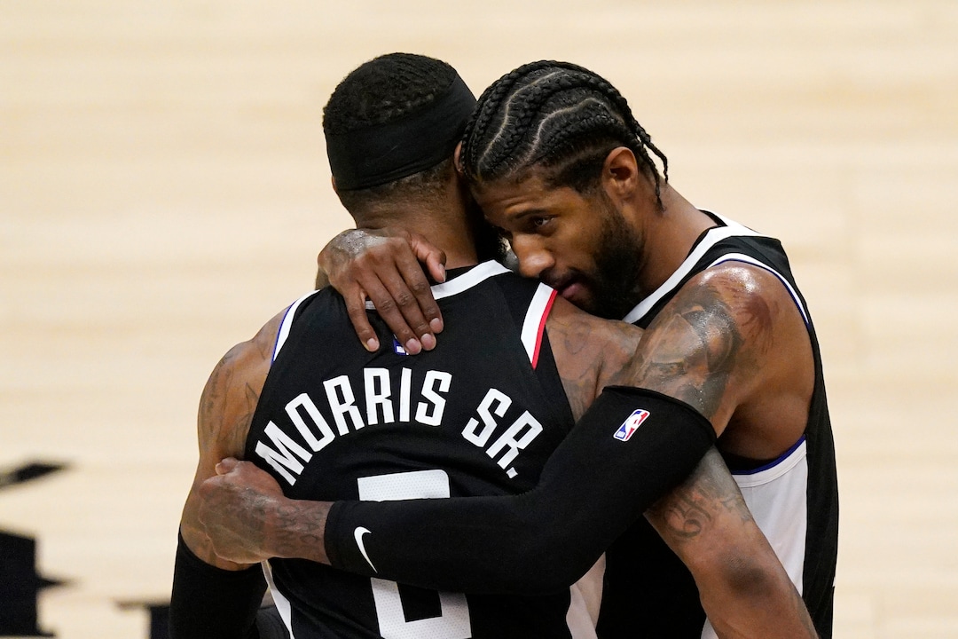 Los Angeles Clippers guard Paul George, right, hugs forward Marcus Morris Sr. during a timeout in the second half of Game 3 of a second-round NBA basketball playoff series against the Utah Jazz Saturday, June 12, 2021, in Los Angeles. (AP Photo/Mark J. Terrill)