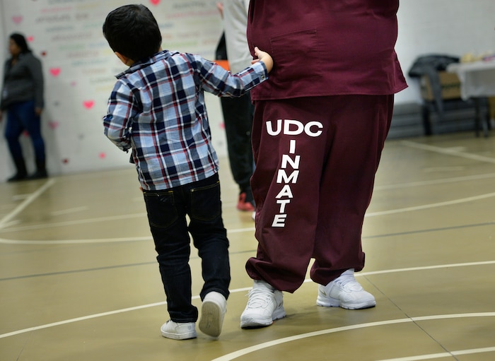 (Scott Sommerdorf   |  The Salt Lake Tribune)   Elicia Chavez's son Damiano walks near his mom as they visit in the prison gymnasium during "Kids Day" at the Utah State Prison, Saturday, October 7, 2017. 