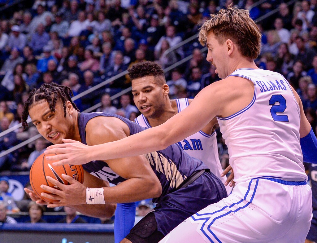 (Leah Hogsten  |  The Salt Lake Tribune) Oral Roberts Golden Eagles guard Deondre Burns (2) is pressed by Brigham Young Cougars forward Yoeli Childs (23) and Brigham Young Cougars guard Zac Seljaas (2). Brigham Young University defeated Oral Roberts, 79-73, Dec. 28, 2019 at the Marriott Center in Provo. 