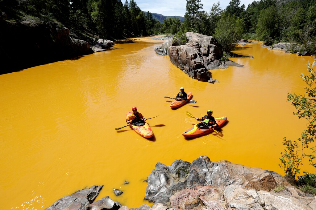 (Jerry McBride | The Durango Herald via AP) In this Thursday, Aug. 6, 2015 file photo, people kayak in the Animas River near Durango, Colo., in water colored yellow from a mine waste spill. A crew supervised by the U.S. Environmental Protection Agency has been blamed for causing the spill while attempting to clean up the area near the abandoned Gold King Mine. Tribal officials with the Navajo Nation declared an emergency on Monday, Aug. 10, as the massive plume of contaminated wastewater flowed down the San Juan River toward Lake Powell in Utah, which supplies much of the water to the Southwest.
