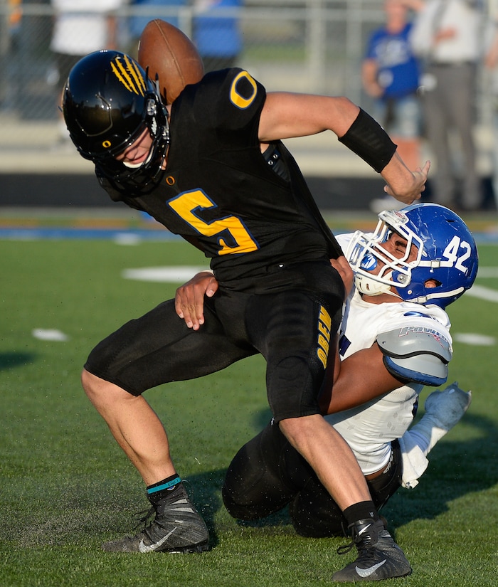 (Francisco Kjolseth  |  The Salt Lake Tribune)  Orem's quarterback Cooper Legas is taken down by Bingham's Sione Fotu in the first half of the game Thursday, Aug. 16, 2018 in Orem.