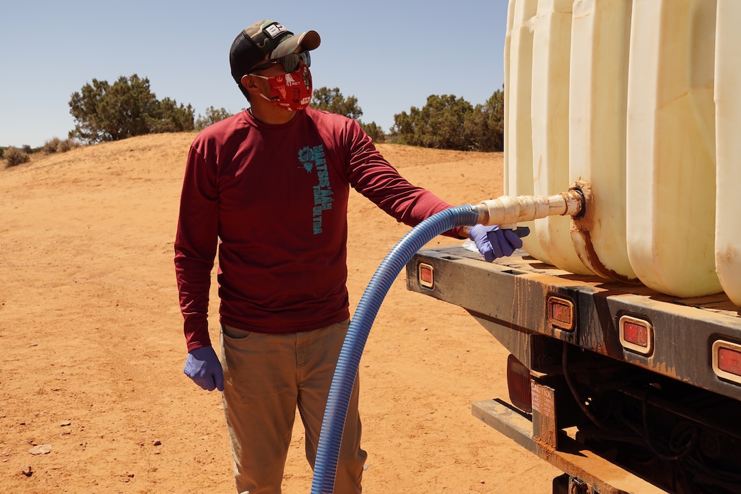 (Zak Podmore | The Salt Lake Tribune) Donovan Smallcanyon, a water and solar technician for DigDeep's Navajo Water Project, fills an underground cistern at a remote home on Piute Mesa on July 1, 2020.