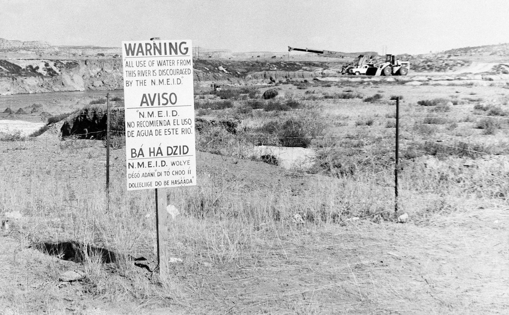 (AP file photo) In this Nov. 13, 1979, while United Nuclear Corp. uses a combination of hand work and heavy machinery to clear up a uranium tailings spill, signs along the Rio Puerco warn residents in three languages to avoid the water in Church Rock, N.M.