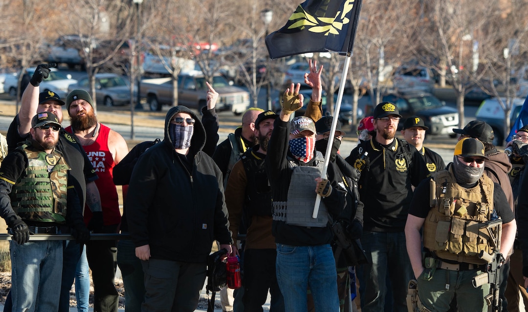 (Francisco Kjolseth  | The Salt Lake Tribune) Heavily armed member of the Proud Boys, a far-right, neo-fascist organization, flash the Q symbol as a small group carrying a Black Lives Matter flag walk amongst Trump supporters listening to speeches at the State Capitol in Salt Lake City on Wednesday, Jan. 6, 2021.