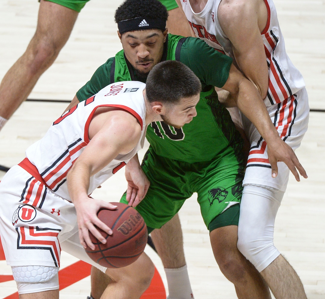(Leah Hogsten  |  The Salt Lake Tribune) Utah Valley Wolverines guard Jaden McClanahan (10) is sandwiched by Utah Utes center Branden Carlson (35) and Utah Utes guard Rylan Jones (15) as the Utes host Utah Valley University on Tuesday, Dec. 15, 2020 at the Jon M. Huntsman Center. The Utes won 75-67.
